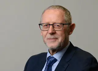 chris-lincoln-rowe-solicitors Man in a black suit and a blue tie posing for a picture