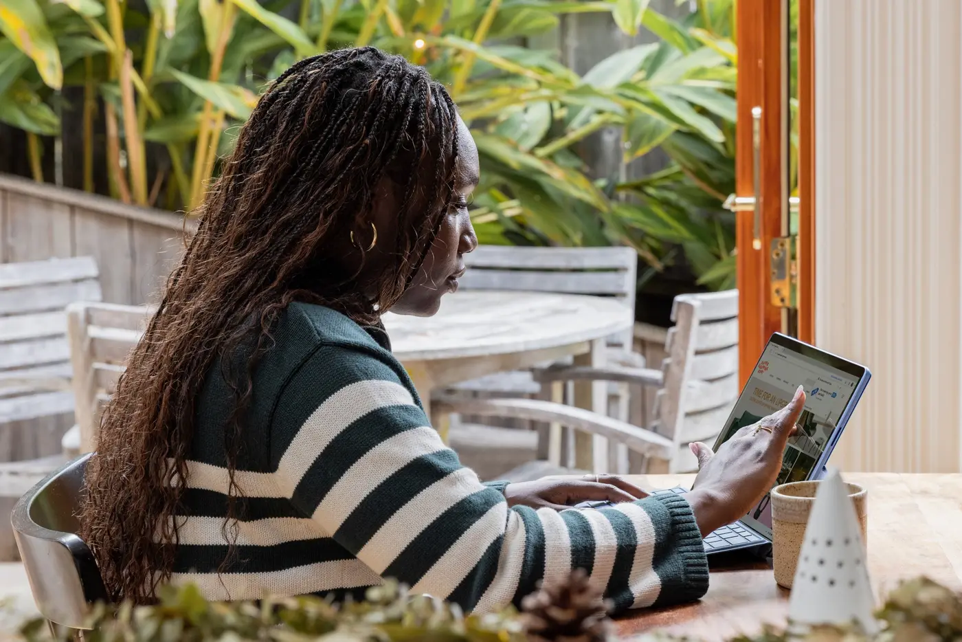 Woman wearing a striped top reading a document on the laptop