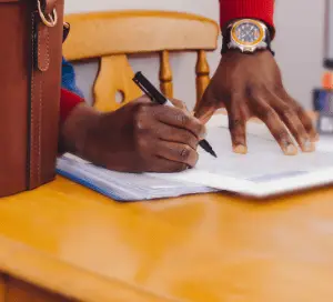 Man in red jumper signing contract