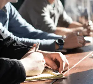 People in a meeting making notes